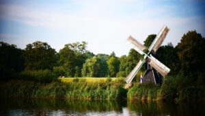 Ein Flussufer, dahinter eine Windmühle